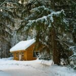Charming winter cabin nestled among snowy evergreens in Duluth, MN.