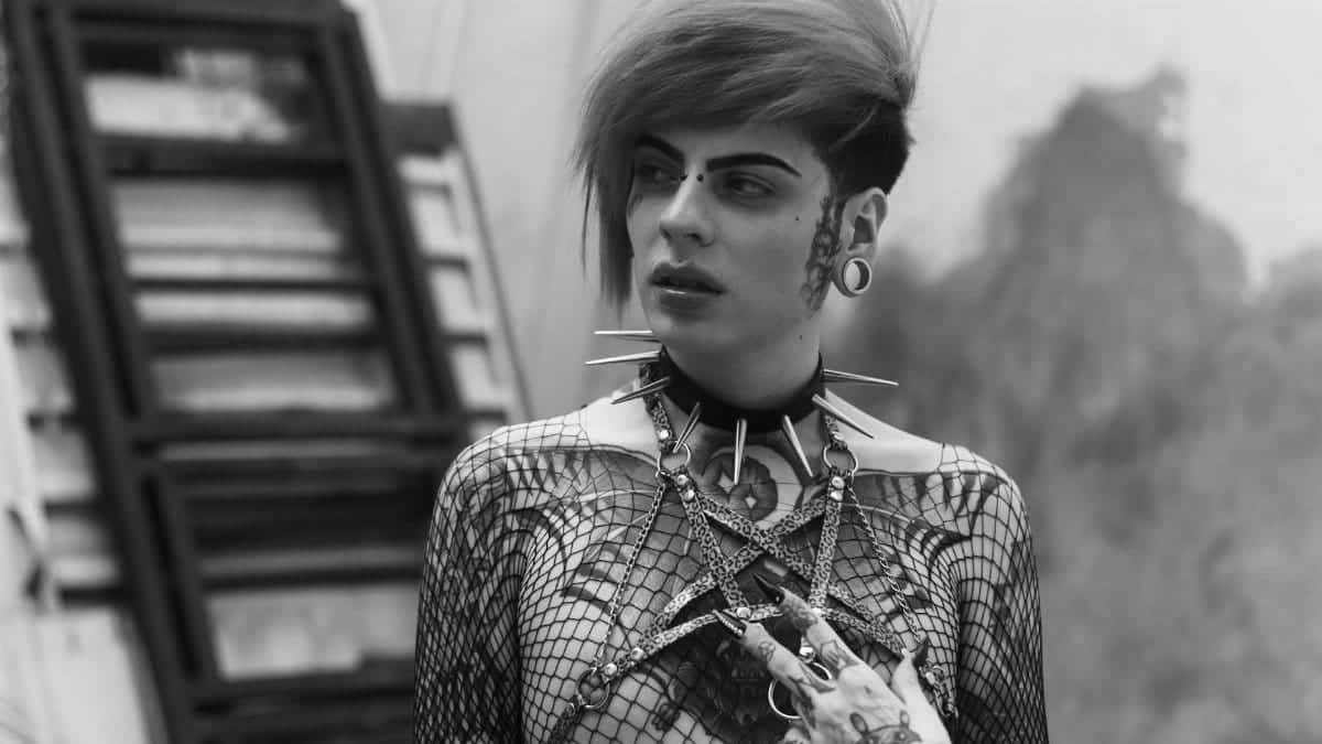 Monochrome portrait of a tattooed individual with punk fashion in urban Mexico City.
