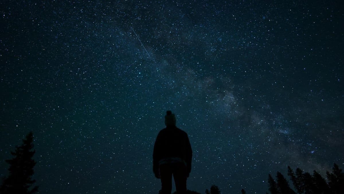 A captivating silhouette of a person stargazing under the Milky Way in Naples, Idaho.