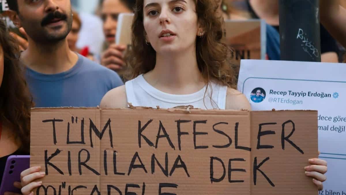 A passionate animal rights protest with a woman holding a sign in an urban street.