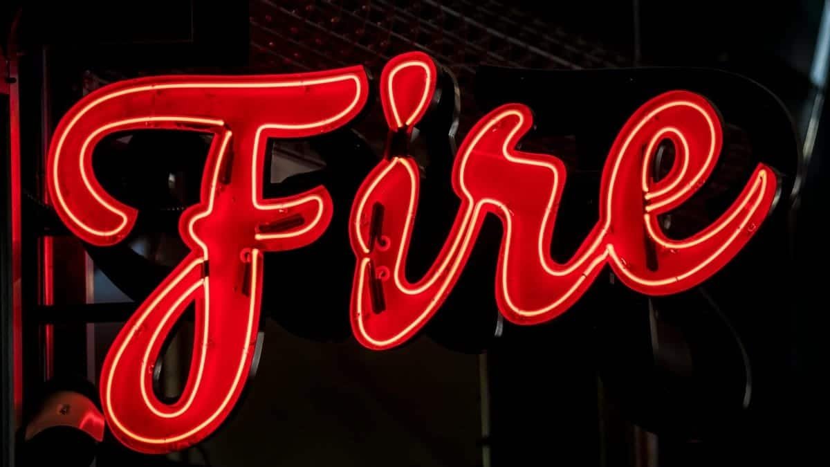 A striking red neon sign spelling 'Fire' in a dark setting, ideal for urban themes.