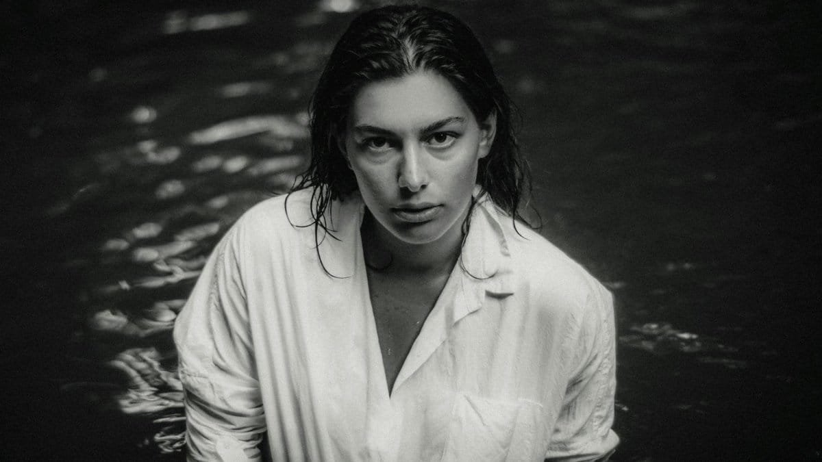 Striking black and white portrait of a woman in water, capturing intense emotions.