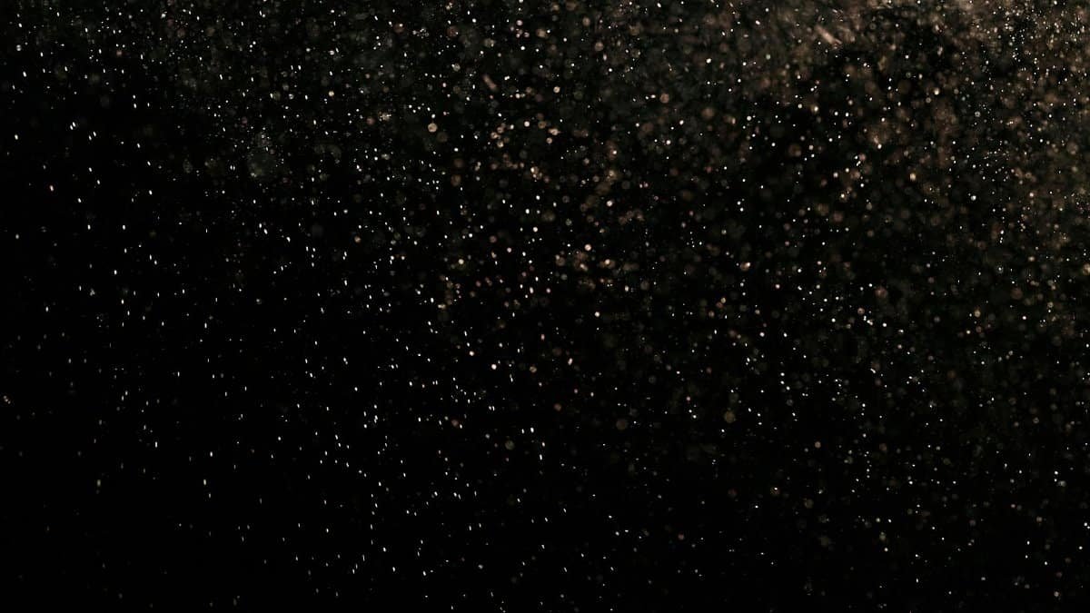 Mystical black texture with floating dust particles creating an abstract effect.