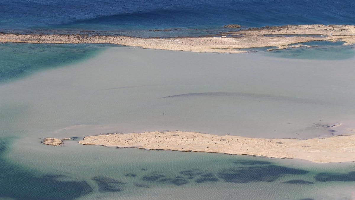 A tranquil aerial view of a tropical lagoon with azure waters and sandy shores.
