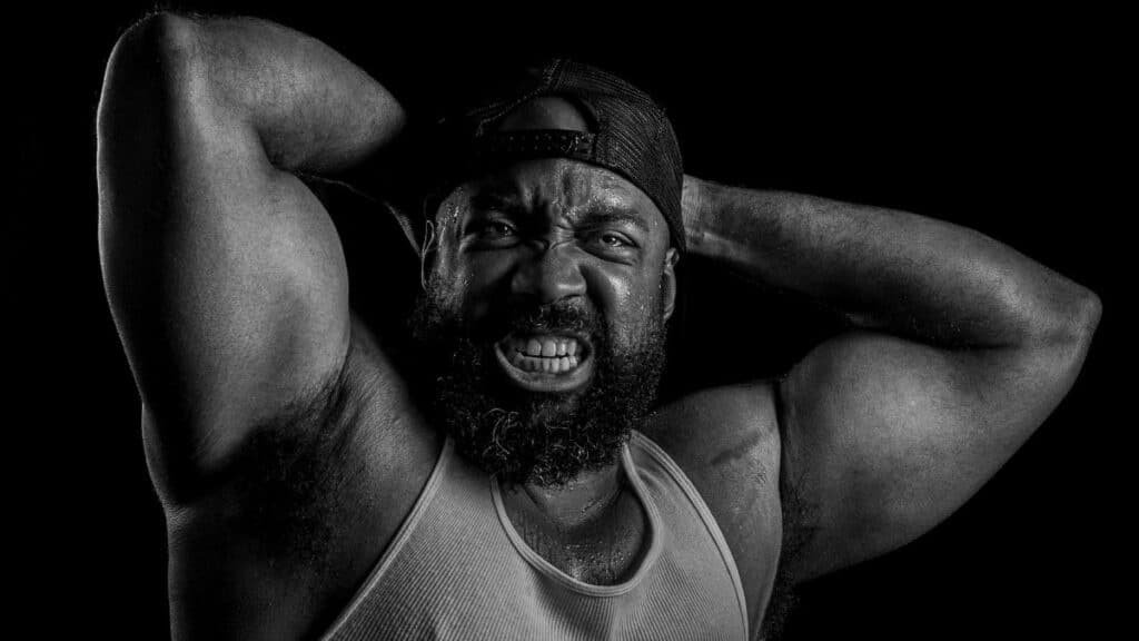 Powerful black and white portrait of a bodybuilder showcasing strength and determination.