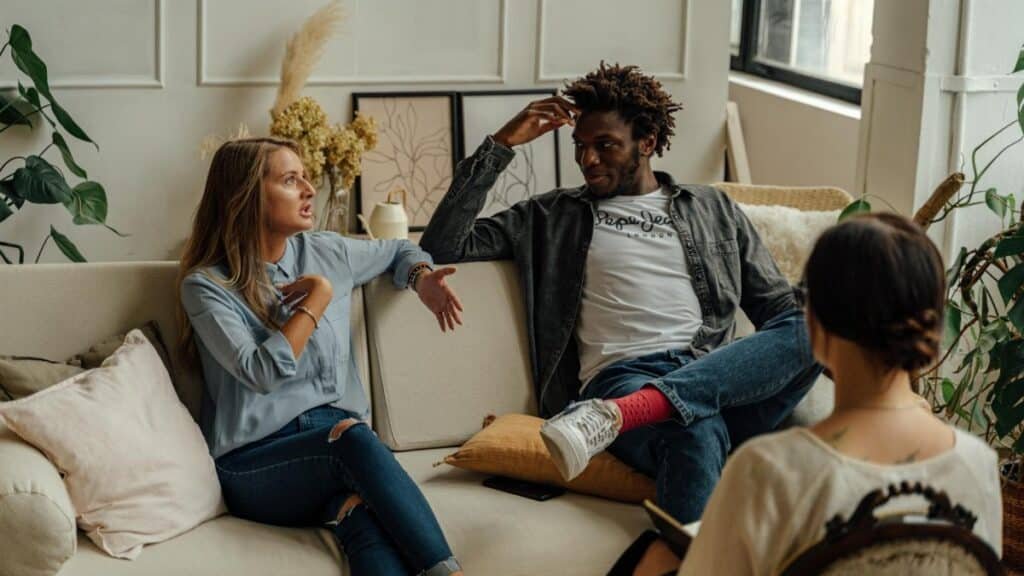A couple is engaged in a lively conversation during a therapy session with a counselor.