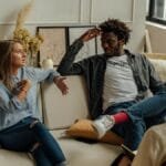A couple is engaged in a lively conversation during a therapy session with a counselor.