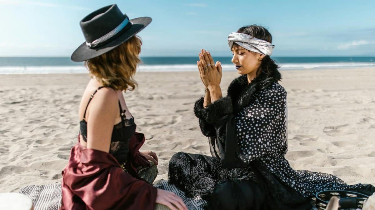 Two women practicing meditation and relaxation on a peaceful beach.