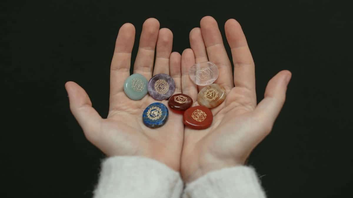 A close-up image of chakra stones held in open hands, showcasing spiritual balance.