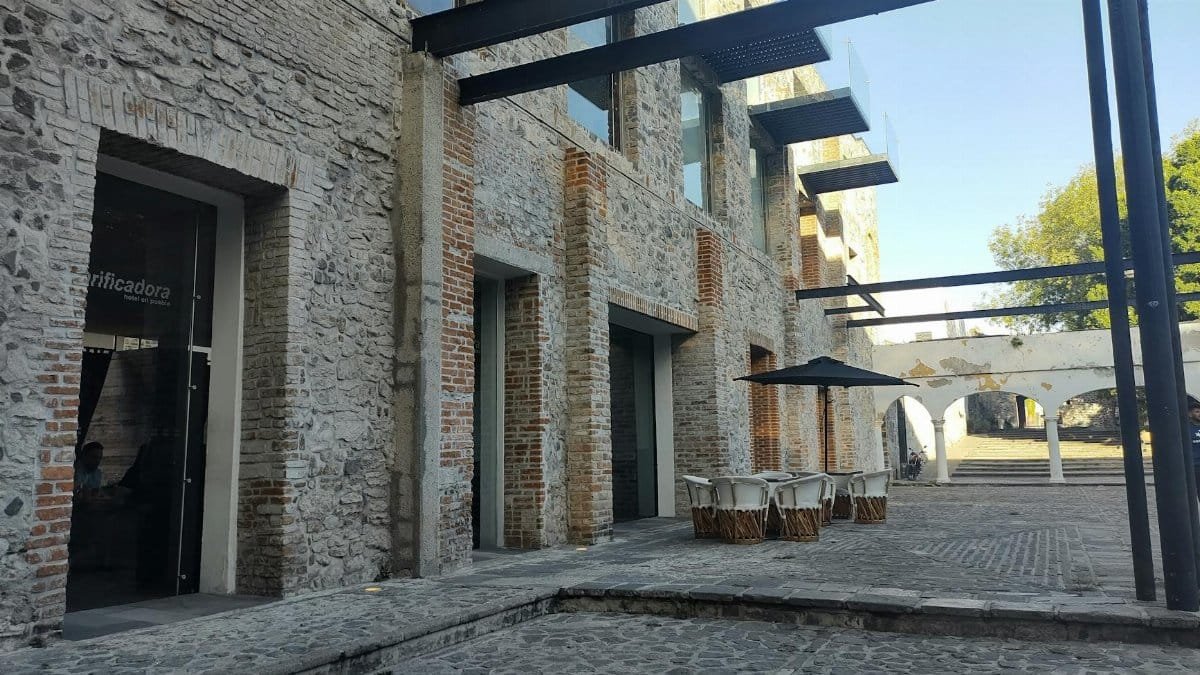 Stone building with modern elements and outdoor seating, showcasing urban architecture.