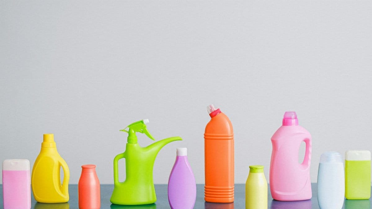 A vibrant assortment of cleaning product containers arranged on a reflective surface, perfect for household sanitation themes.
