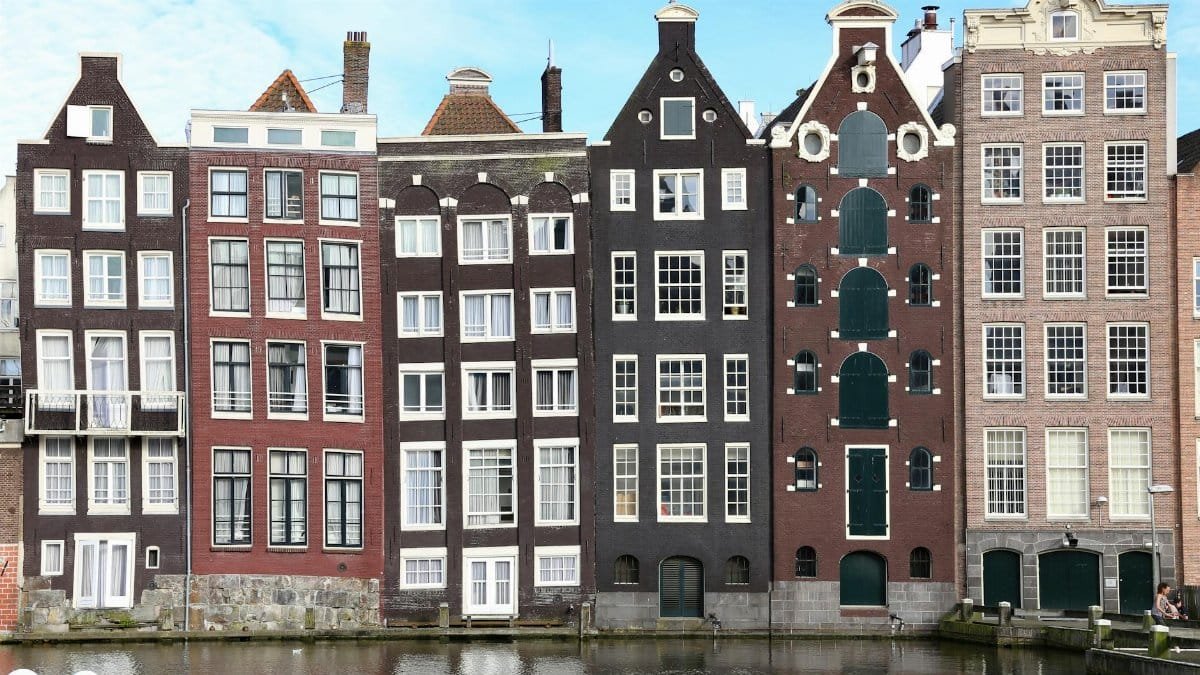 Scenic view of iconic narrow canal houses in Amsterdam showing unique architecture.