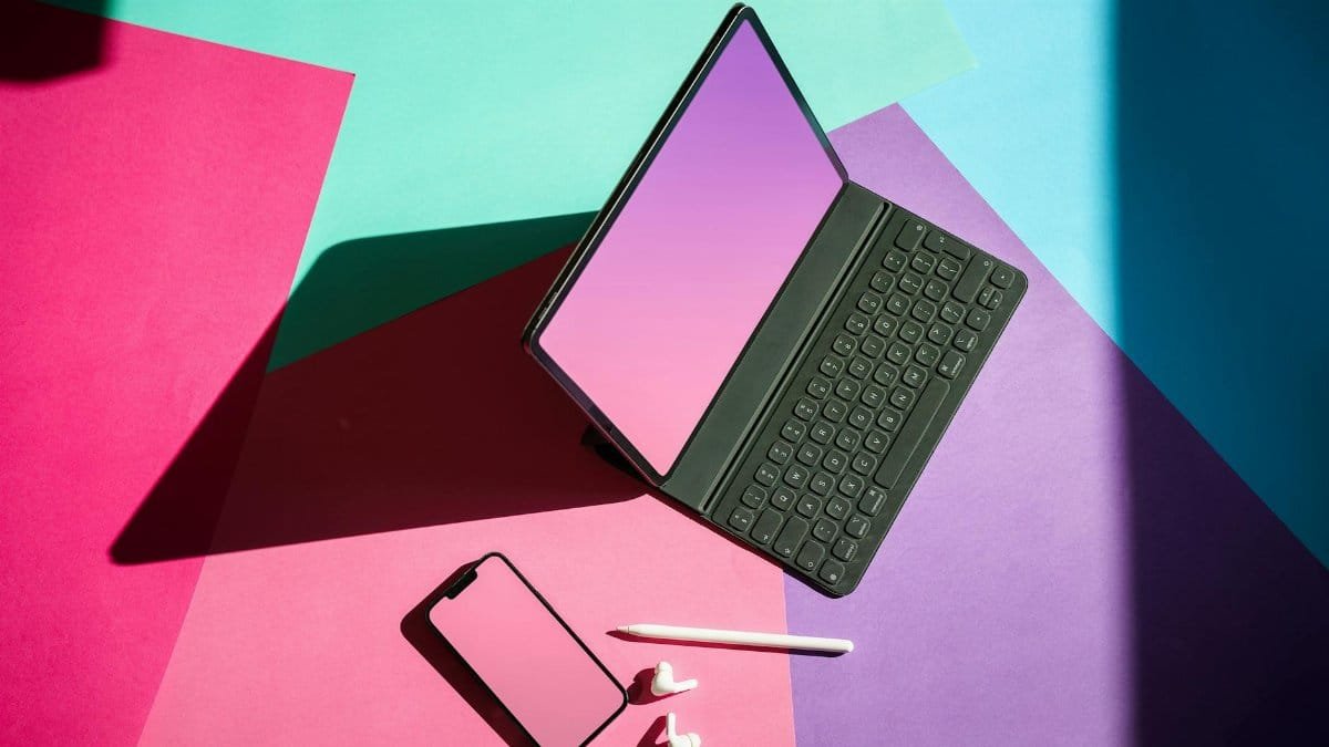 Vibrant flat lay featuring a tablet, smartphone, and stylus on a colorful background.