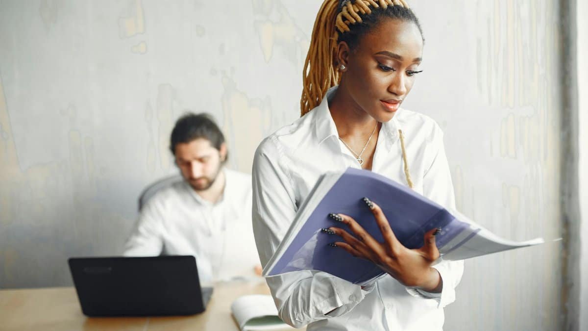 Two professionals collaborating in a modern, diverse office setting, focusing on teamwork and productivity.