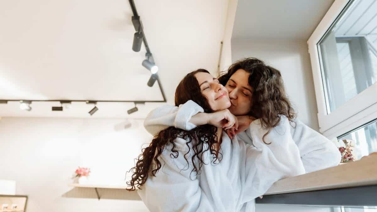 Happy couple shares intimate moment in cozy indoor setting, exuding warmth and closeness.