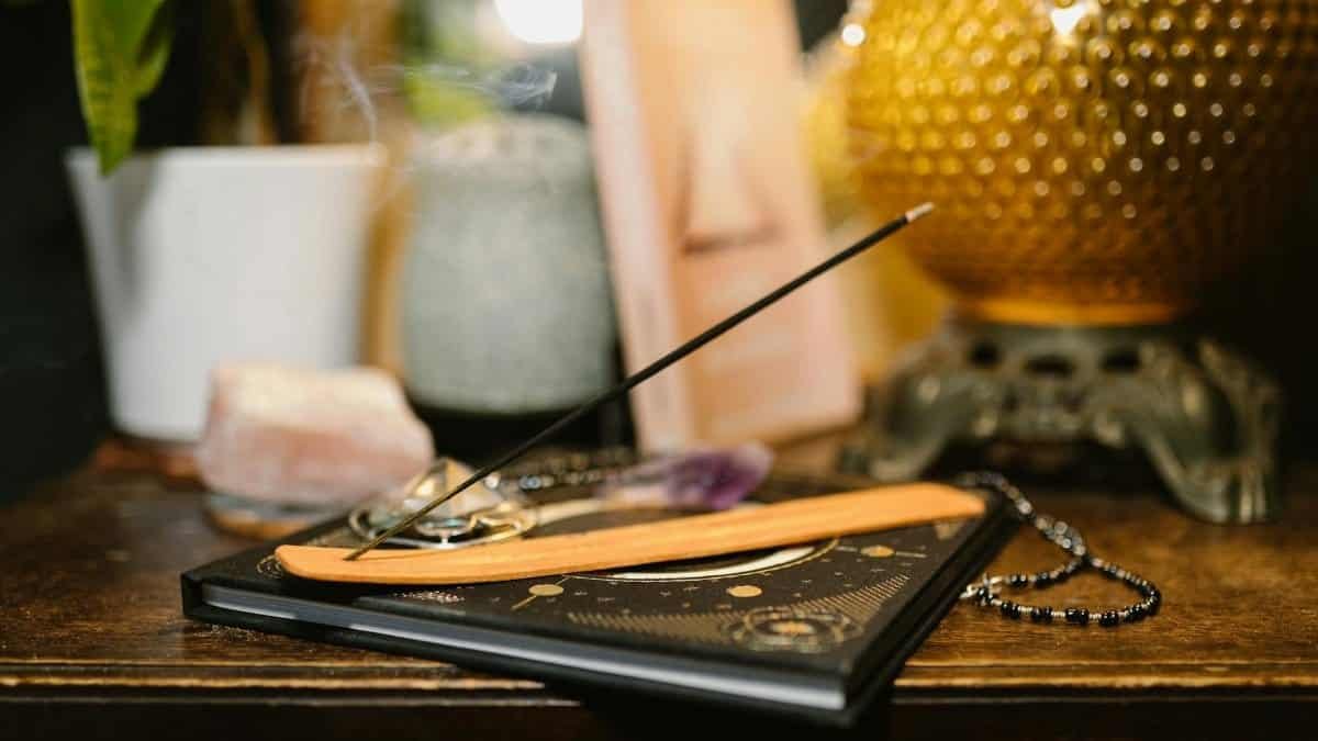 A tranquil setting featuring incense, crystals, and a glowing lamp for spiritual rituals.