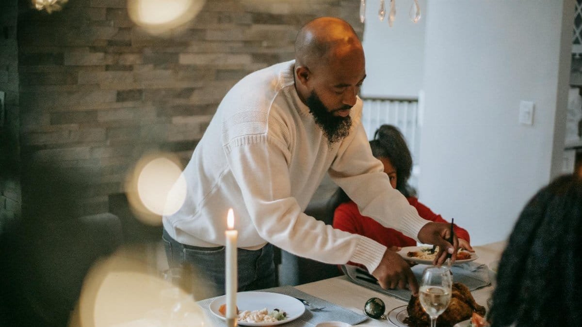 A family gathers around a dinner table for a festive meal, creating a warm and inviting atmosphere.