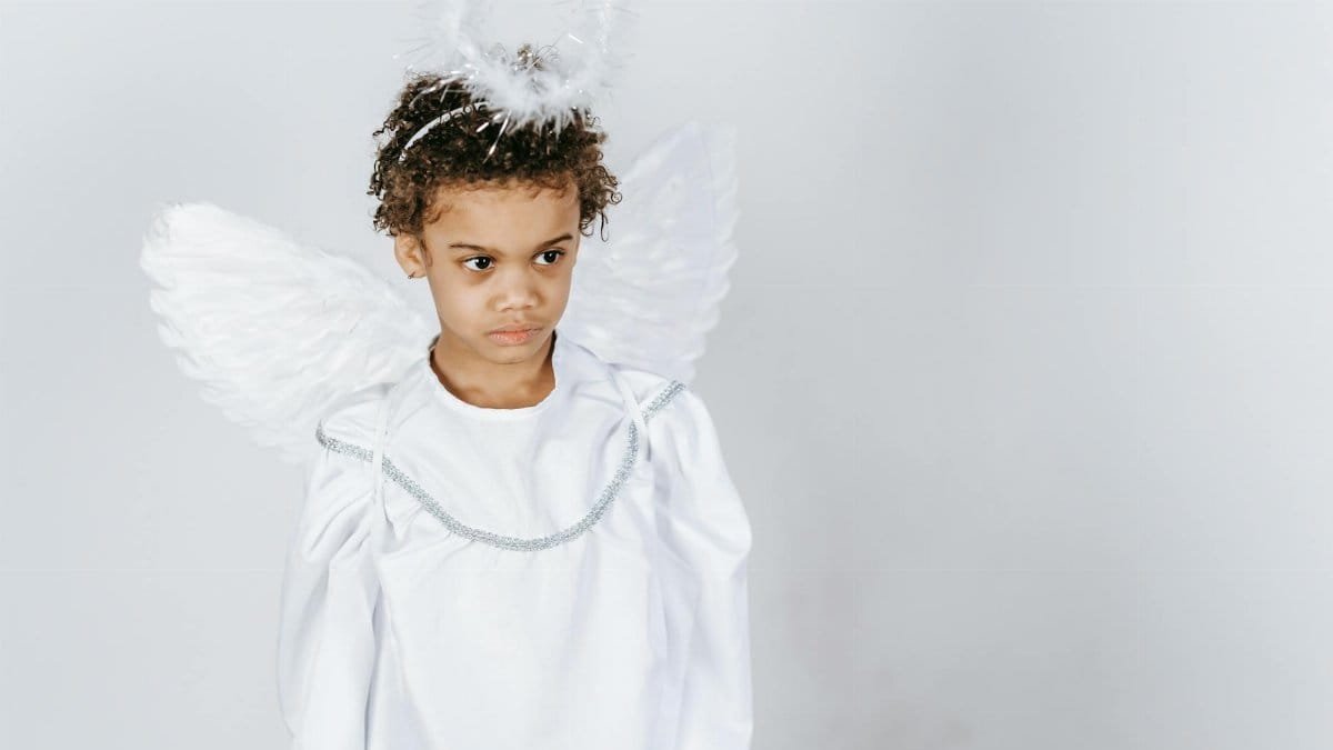 Adorable child in angel costume with halo, exuding serene beauty.