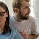 A serious conversation between a man and a woman in a modern office space, focusing on mental health consultation.