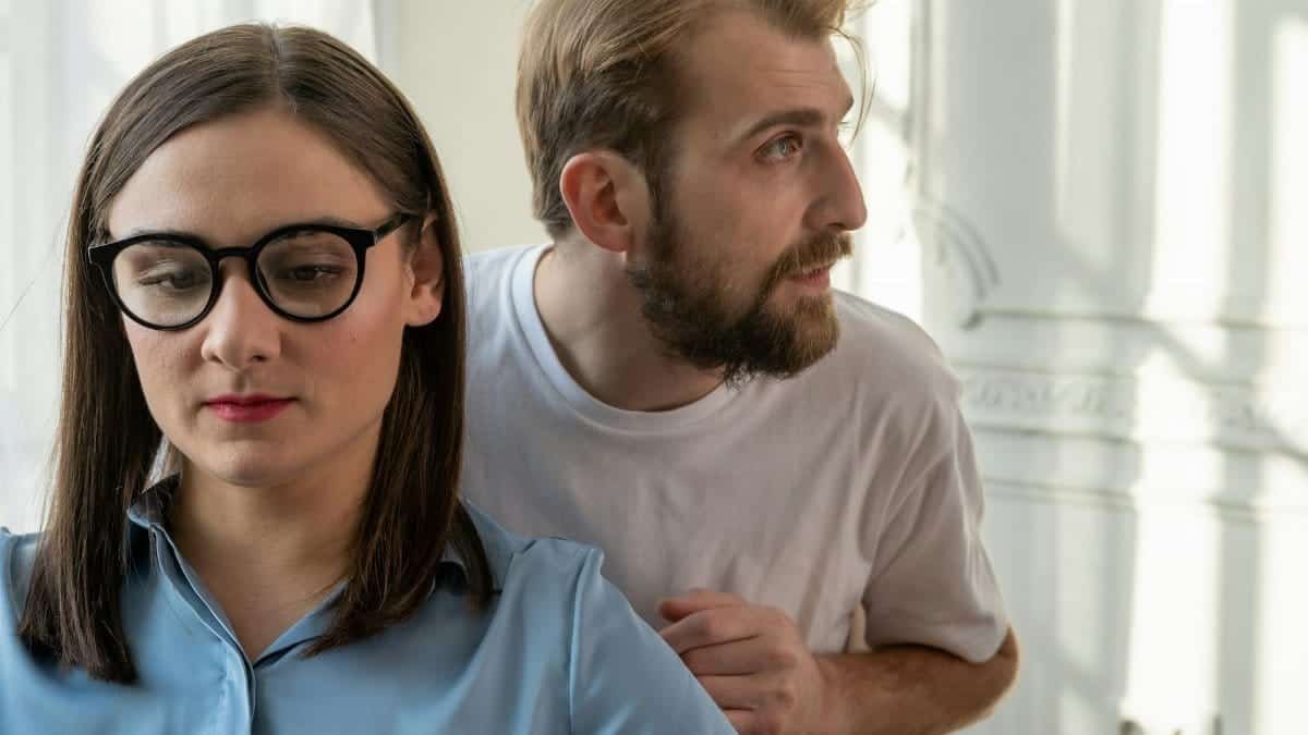 A serious conversation between a man and a woman in a modern office space, focusing on mental health consultation.