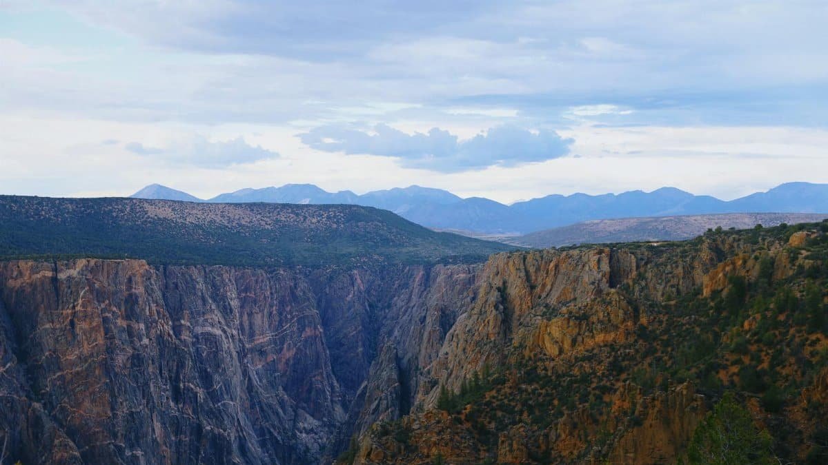 Explore the breathtaking cliffs of Black Canyon, Colorado under clear summer skies.