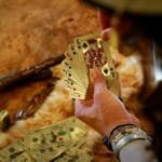 Hand holding playing cards in a Las Vegas casino scene, showcasing gambling elements.