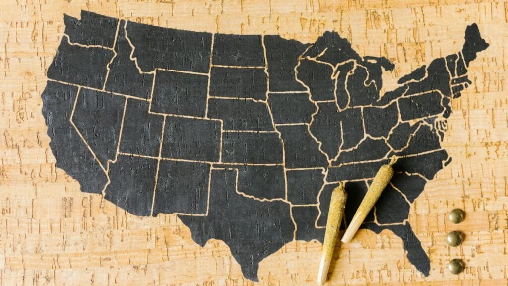 Two cannabis joints placed over a USA map, symbolizing marijuana legalization.