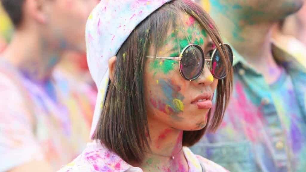 Colorful Holi festival celebration in New York with joyful participants.