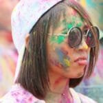 Colorful Holi festival celebration in New York with joyful participants.