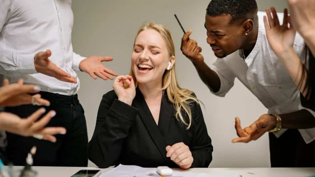 Conceptual image of office conflict with a woman facing workplace pressure surrounded by colleagues.