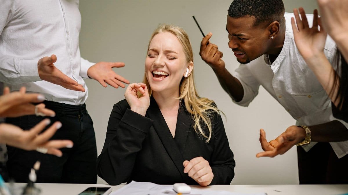 Conceptual image of office conflict with a woman facing workplace pressure surrounded by colleagues.