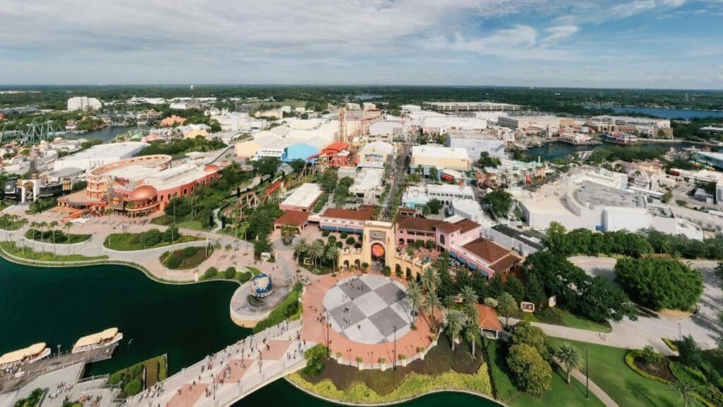 Aerial shot showcasing the vibrant theme park layout of Universal Studios Orlando with lush greenery and blue skies.