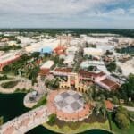 Aerial shot showcasing the vibrant theme park layout of Universal Studios Orlando with lush greenery and blue skies.