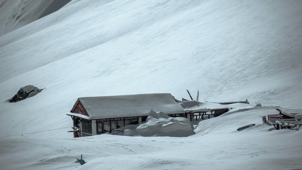 A solitary building buried under snow, illustrating the aftermath of an avalanche.