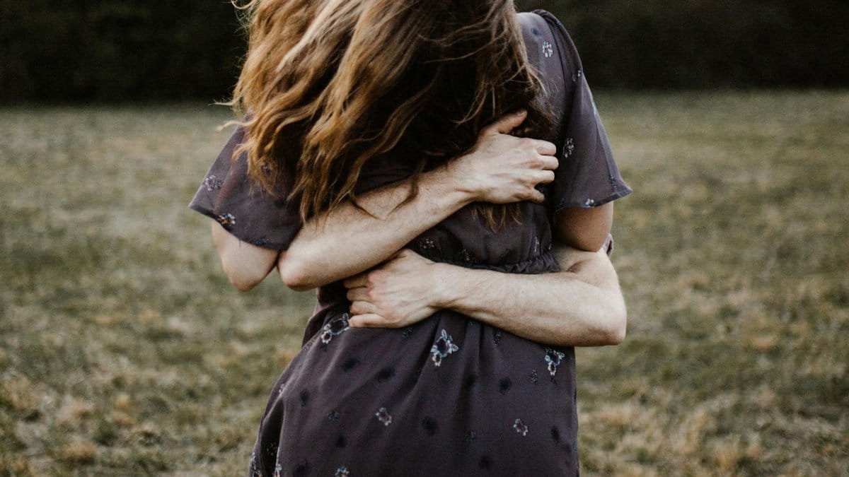 A couple embracing in a peaceful outdoor park setting, symbolizing love and togetherness.