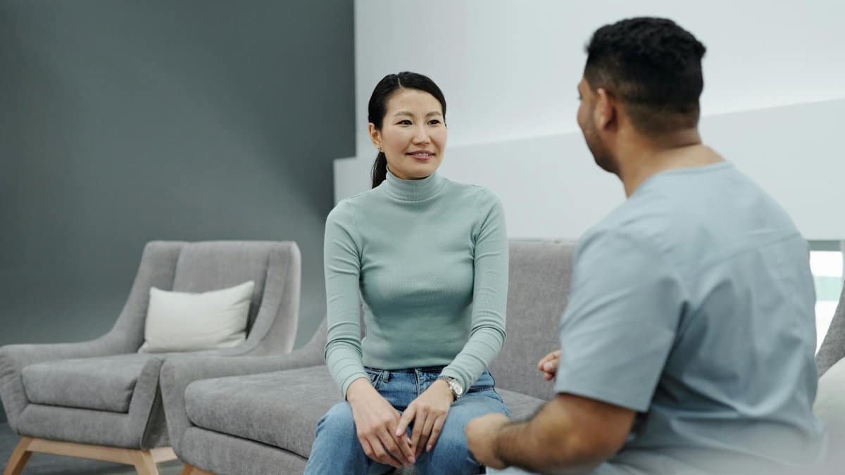 A doctor and patient having a friendly conversation in a modern clinic.