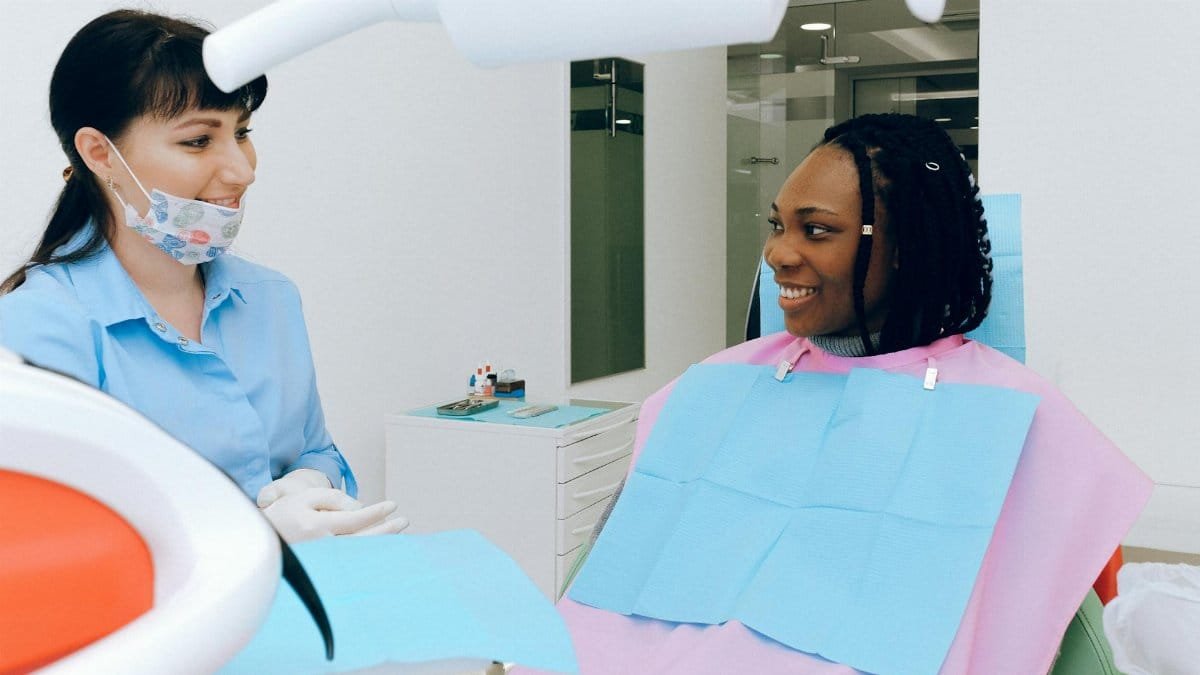 A dentist and patient share a warm conversation during a dental check-up.