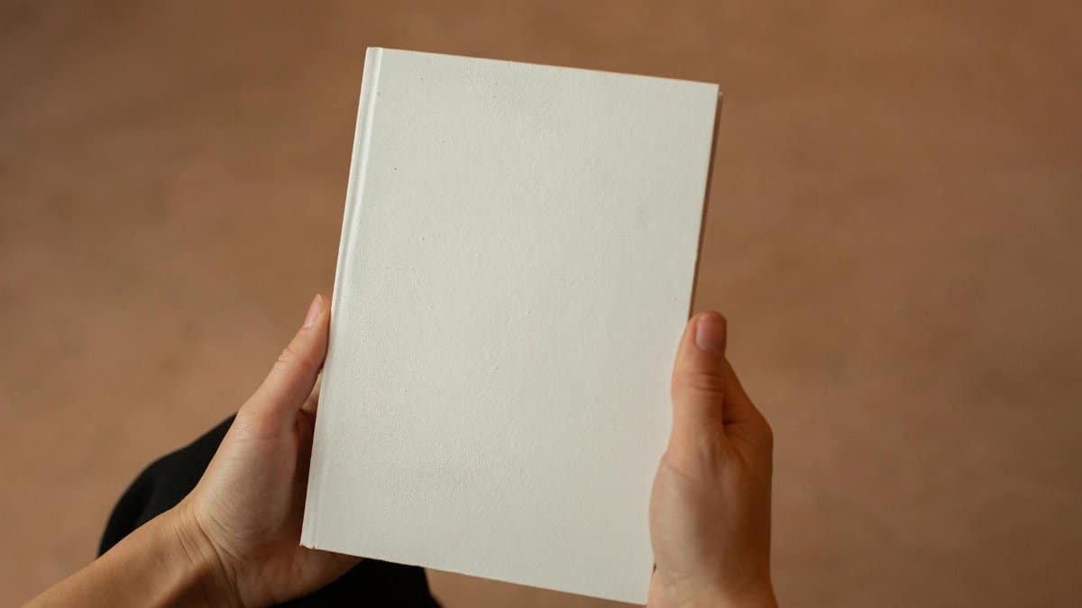 A person holding a blank hardcover book. Perfect for mockup and design templates.
