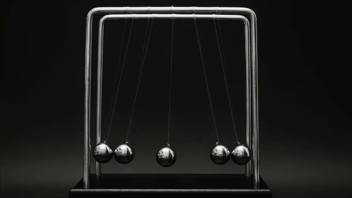 Newton's cradle for physics principles and motion study on a dark background.