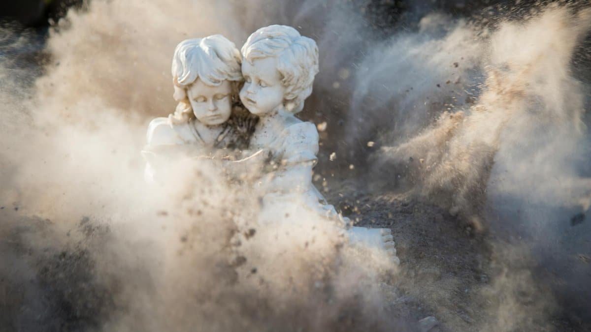Intricate stone statues engulfed in a dynamic dust explosion, creating a dramatic artistic effect.
