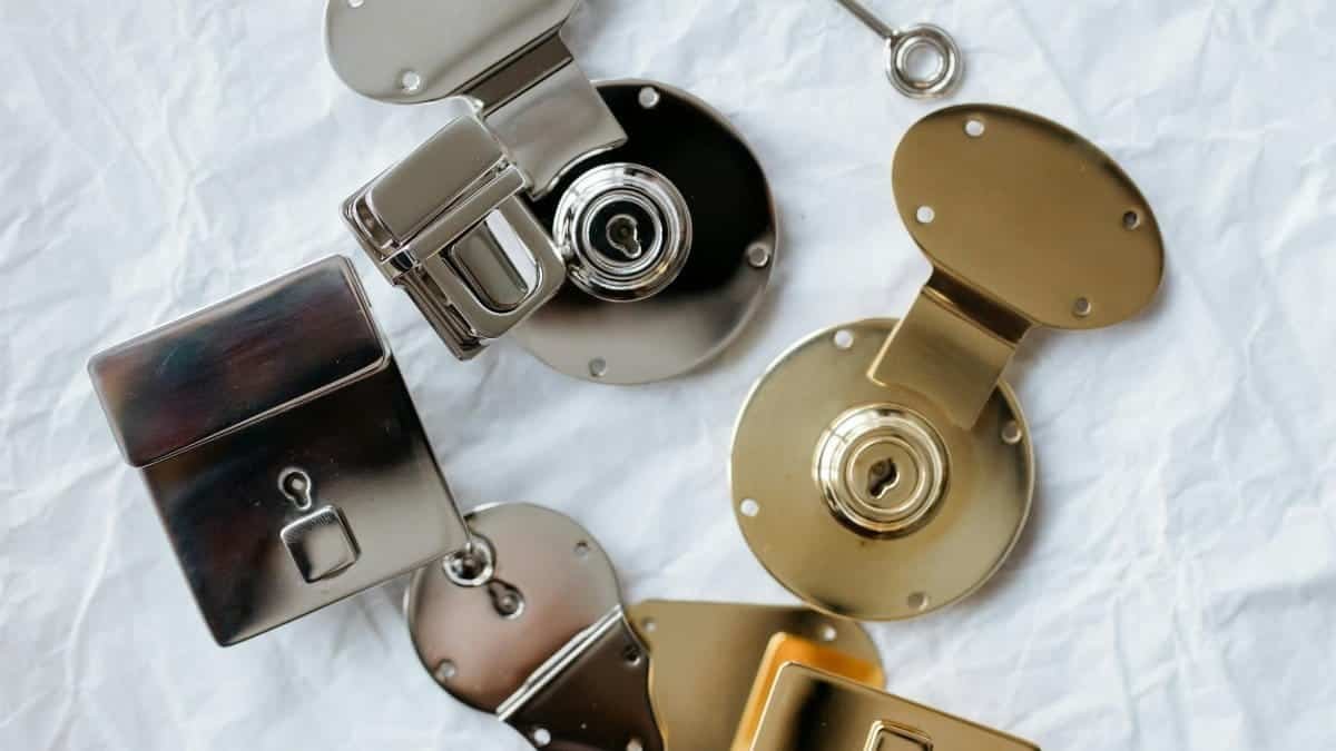 Detailed flat lay of different colored metallic locks and a key on a textured background.