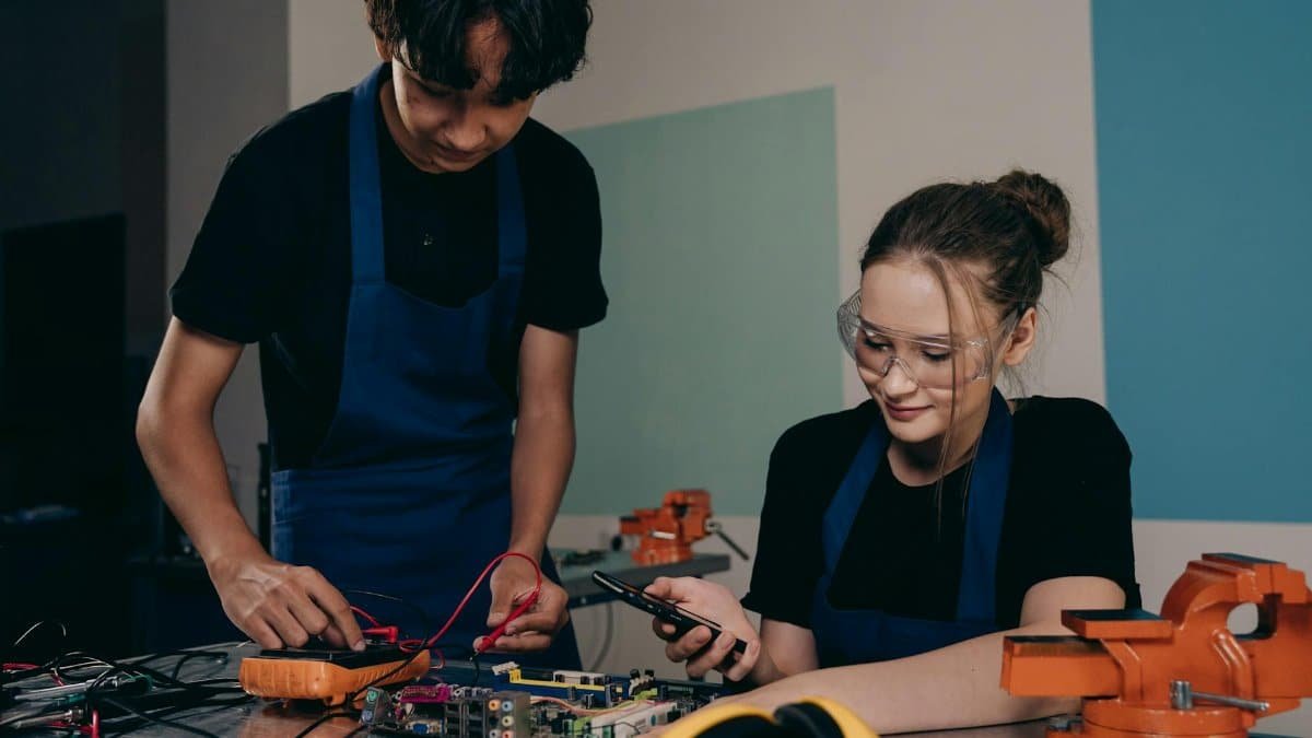 Two young adults working on an electronics project in a lab setting, focusing on circuit design.