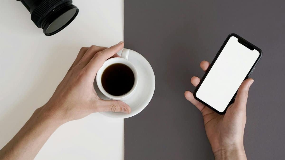 Minimalist workspace featuring a smartphone and black coffee, perfect for productivity and relaxation.
