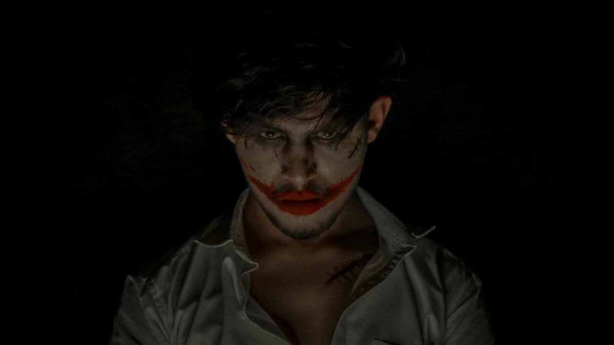 Chilling portrait of a person with eerie makeup in a dark studio setting, perfect for Halloween themes.