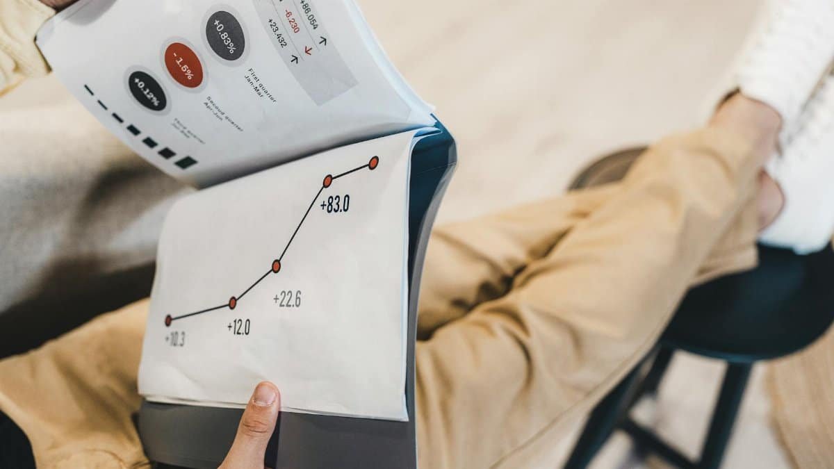 Close-up of a man reviewing business growth charts and statistics in an office setting.