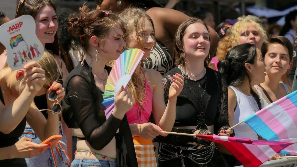 Vibrant group of diverse individuals celebrating at a pride parade in New York City during the day.