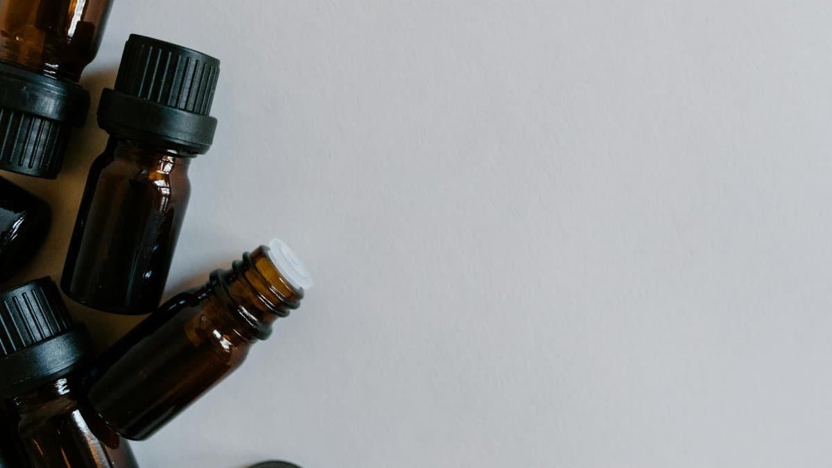 A minimalist arrangement of brown essential oil bottles on a white background, ideal for aromatherapy themes.