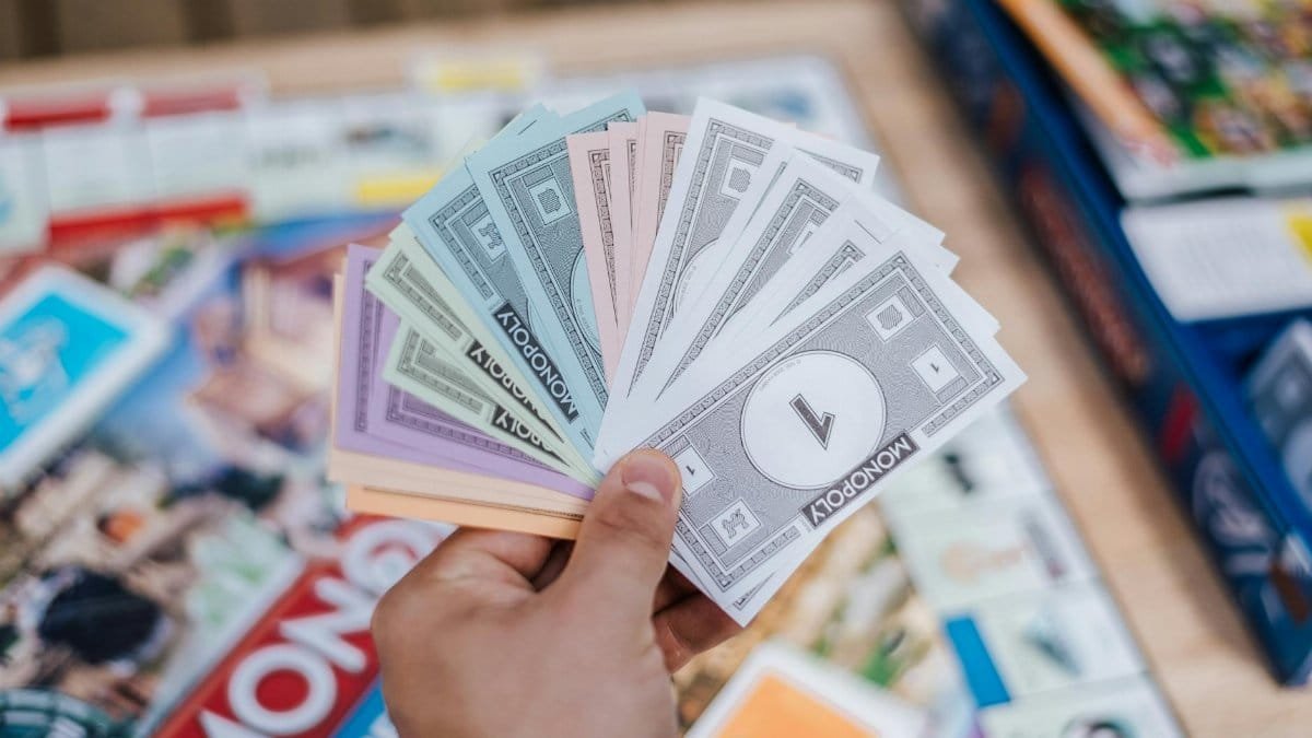Close-up of Monopoly money held during a board game session, with blurred background.