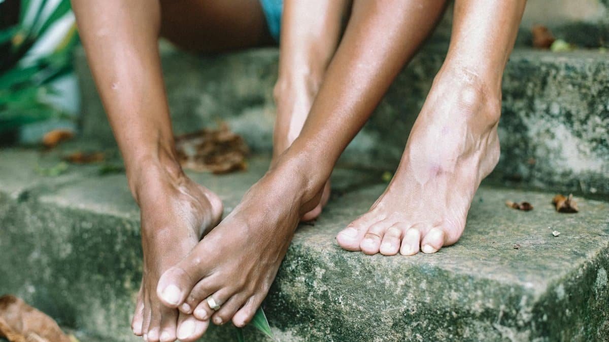 Close-up of two people's feet resting on stone steps, conveying a sense of relaxation.