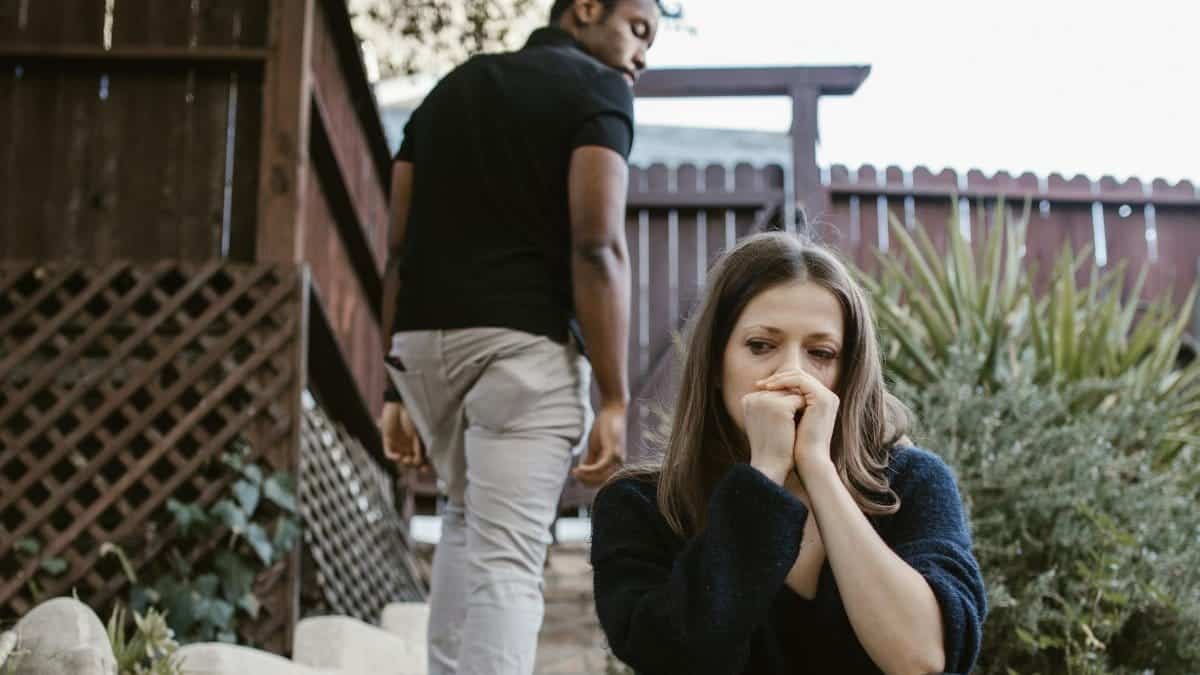 A couple facing emotional struggles captured in an outdoor setting.